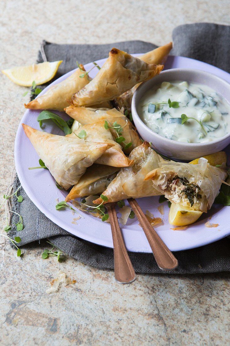Spanakopitas filled with rocket, walnuts and goat's cheese served with lemon and dill tzatziki