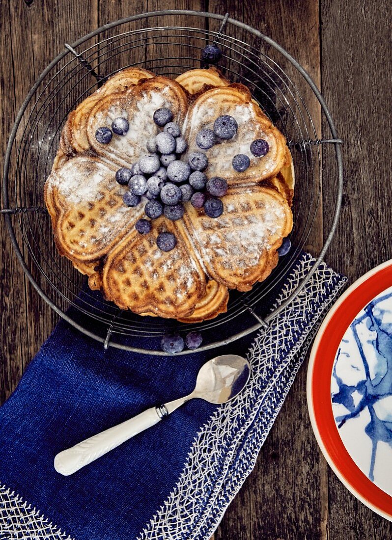 Heart shaped waffles with blueberries and icing sugar