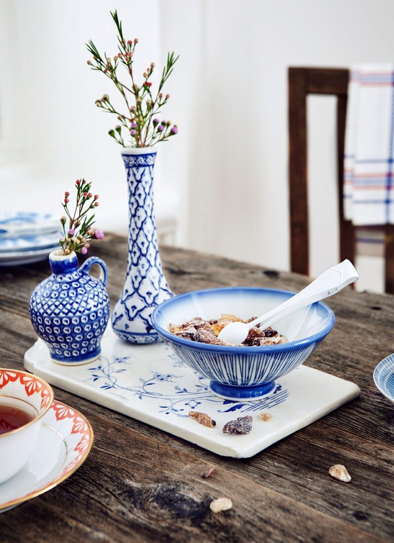 A tea cup, sugar candy and a blue and white table decoration