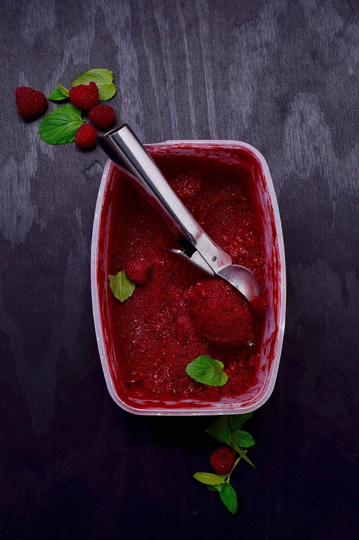 Raspberry sorbet and ice cream in an ice cream maker and mint