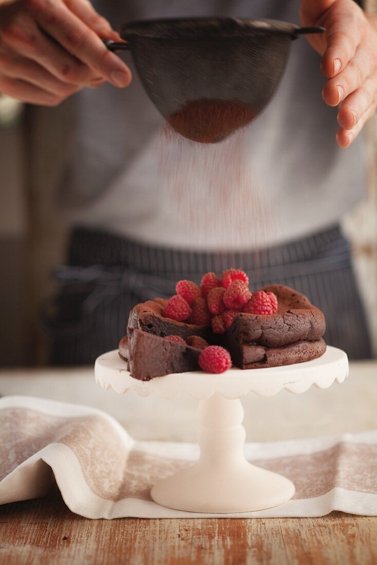 Glutenfreier Schokoladenkuchen mit Himbeeren und Kakaopulver
