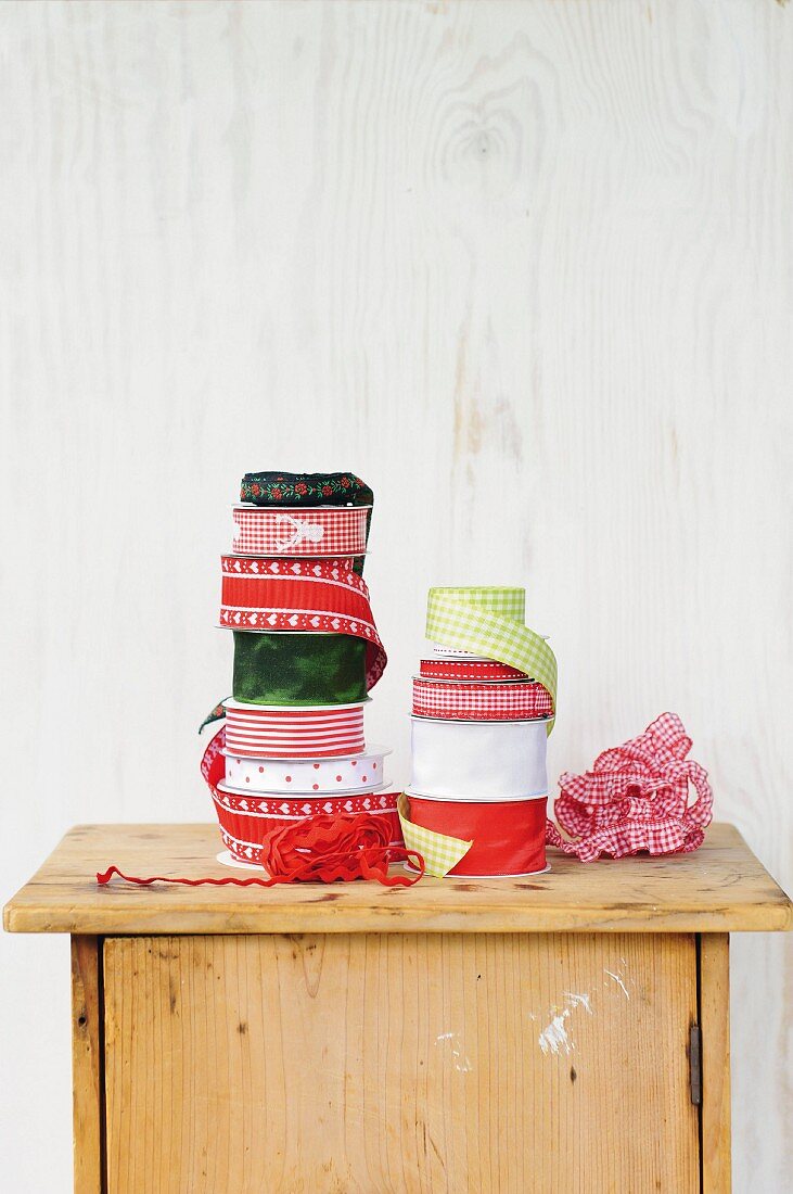 Various rolls of gift ribbon on top of rustic cabinet