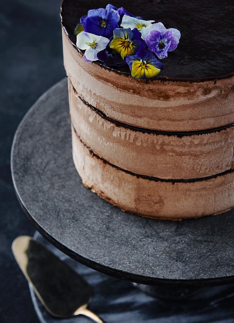 Chocolate cake with chocolate cream and edible flowers