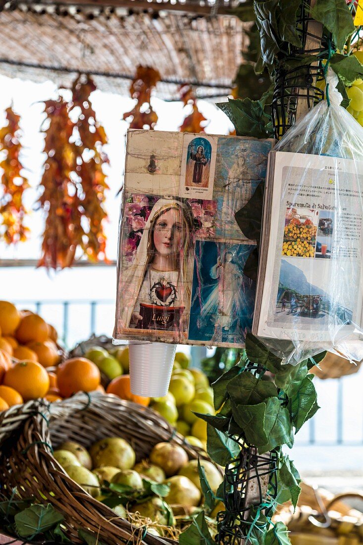 Pictures of saints hanging from a market stand in Positano, Amalfi coast, Italy