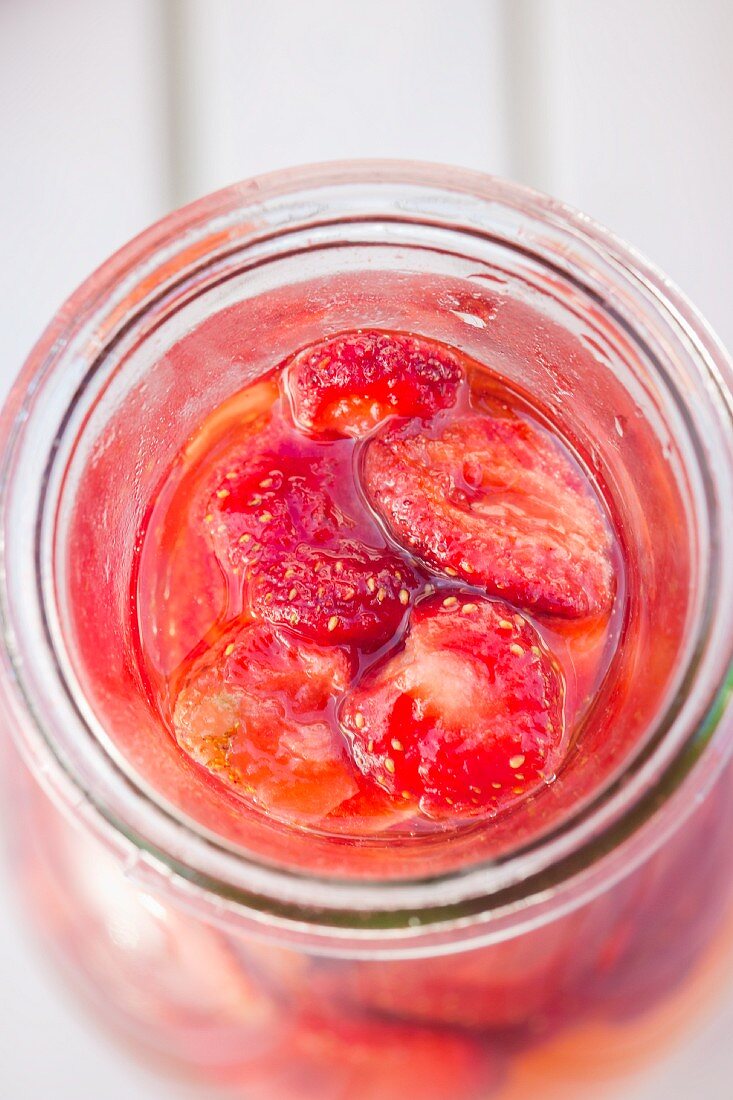 Eine Flasche mit gefriergetrockneten Erdbeeren und Essig (Draufsicht)