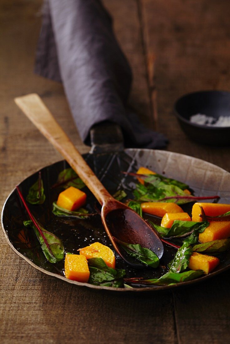 Chard and pumpkin being fried for creamy chard and pumpkin pasta