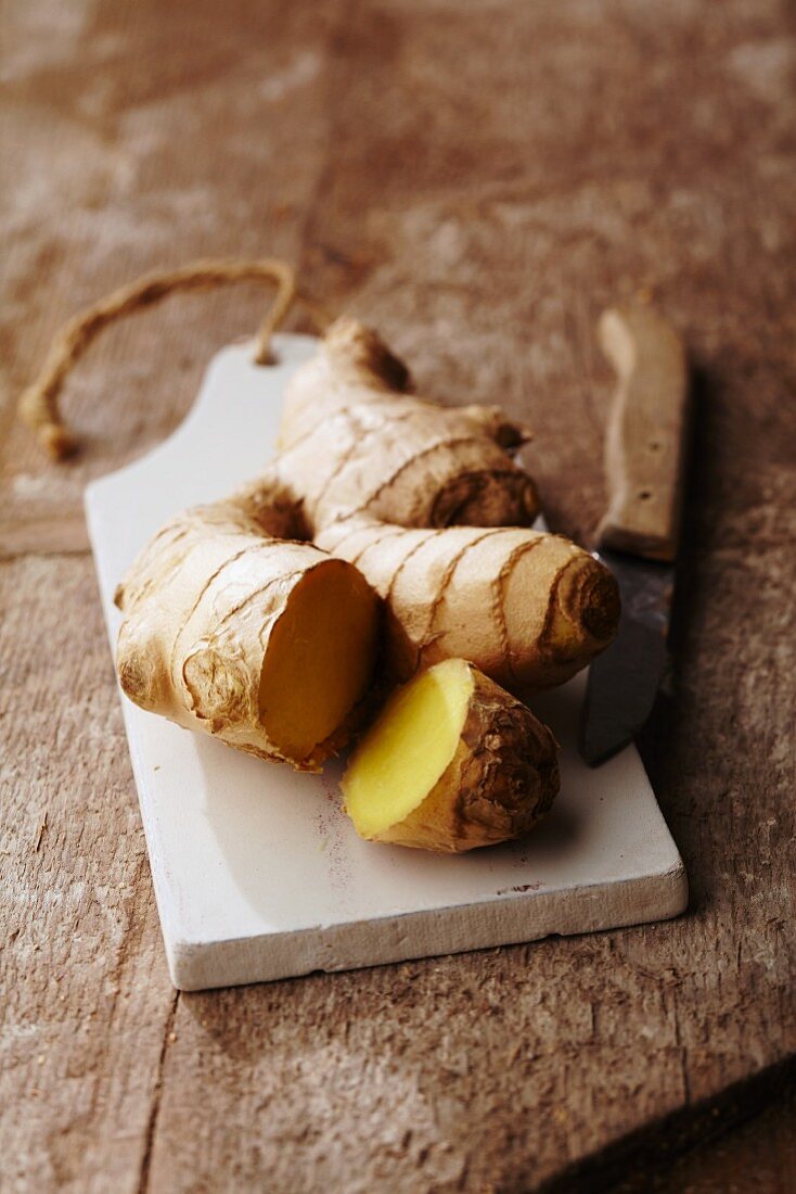 A ginger root on a wooden chopping board