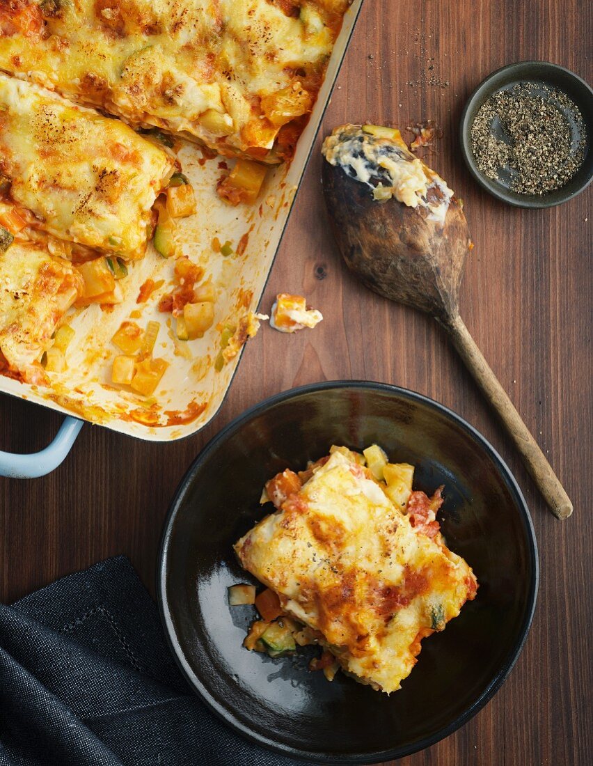 Vegetable lasagne in a baking dish and on a plate