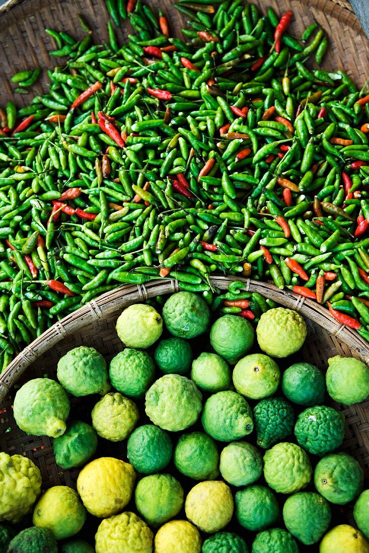 Fresh chilli peppers and kaffir limes at a market (Thailand, Asia)