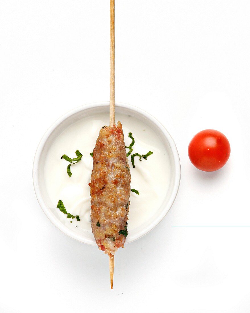 A minced meat kebab with yoghurt sauce