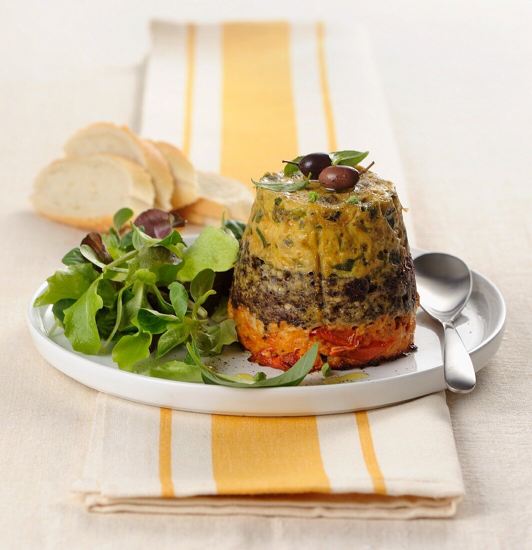 A three-layer vegetable cake with herbs, olives and tomatoes