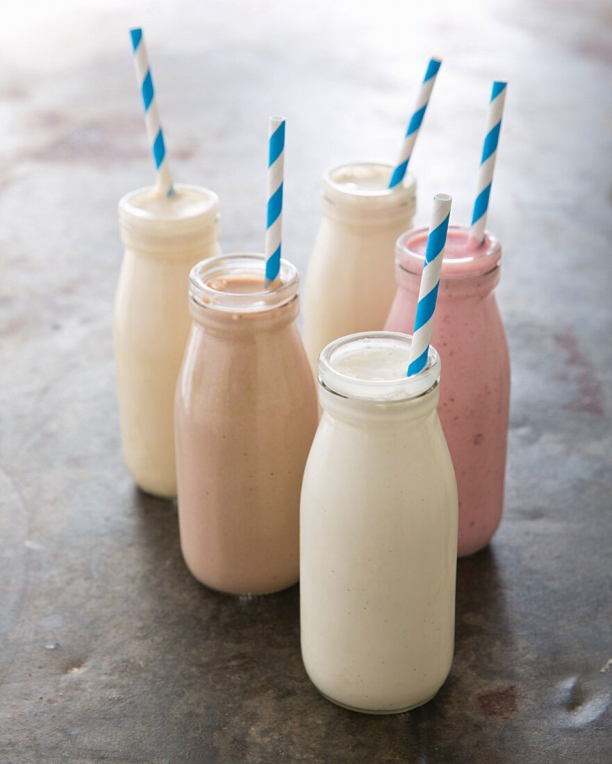 Various milkshakes in bottles with straws: vanilla, strawberry, chocolate, coffee, caramel