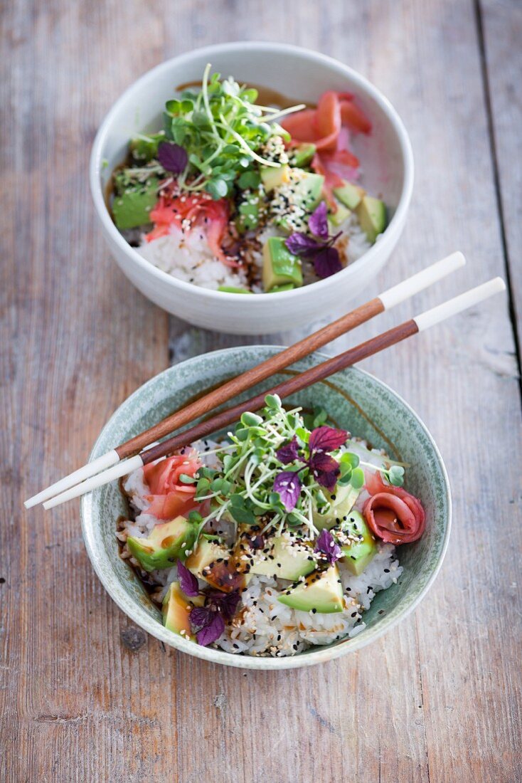 A sushi bowl with avocado, cress, soy sauce and pickled ginger