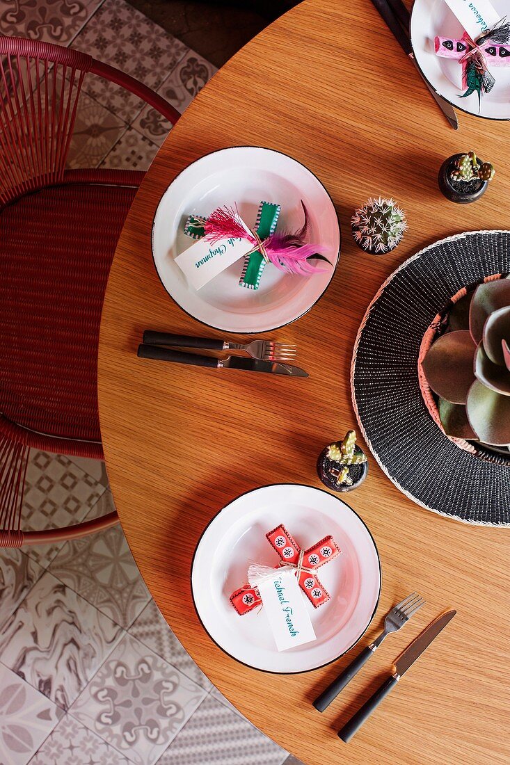 Minimalist table with cross motifs and name cards on a plate