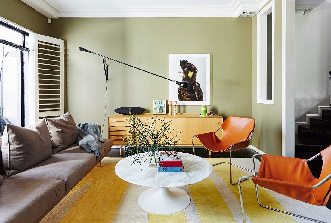 Classic coffee table with round marble top and chairs with cognac-colored leather upholstery