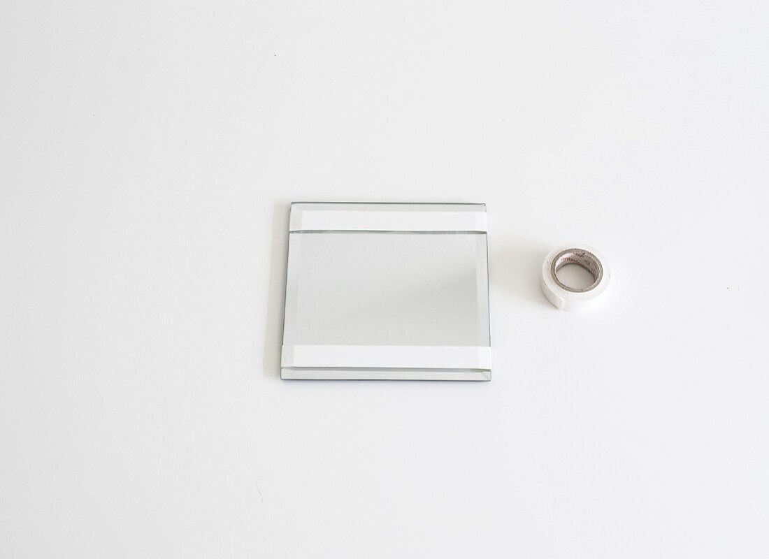Mirror with areas masked with white masking tape