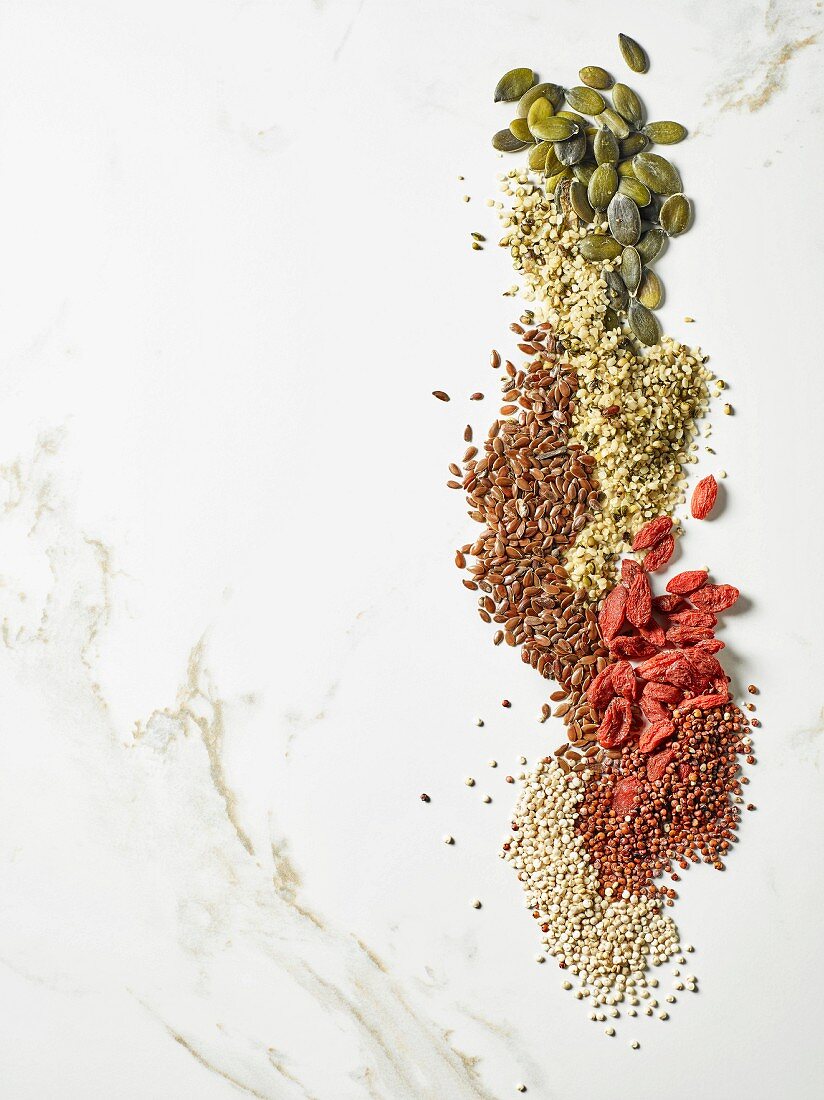 Pumpkin seeds, flax seeds, goji seeds, hemp seeds, white and red quinoa seeds (seen from above)