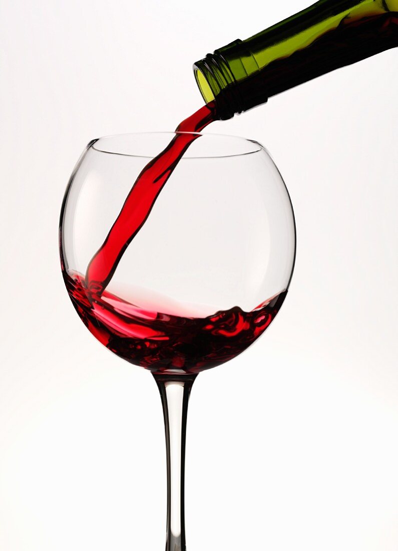 Rotwein in rundes Glas einschenken