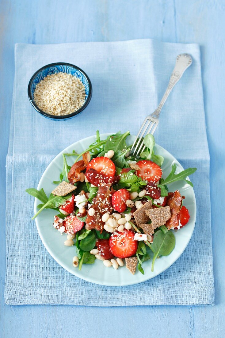 Strawberry salad with bacon, pearl beans, feta cheese, vegetables and strawberry jam
