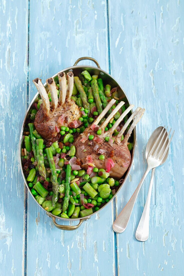 Lamb chops with asparagus, broad beans, peas, red onions and raisins