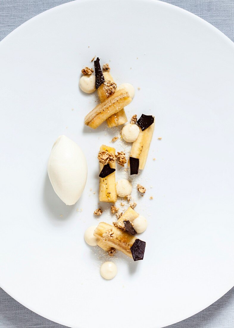 Marinated bananas with grated chocolate, wholemeal muesli, banana cream and vanilla ice cream