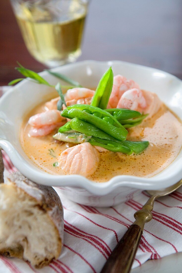 Soup with salmon, prawns and mange tout