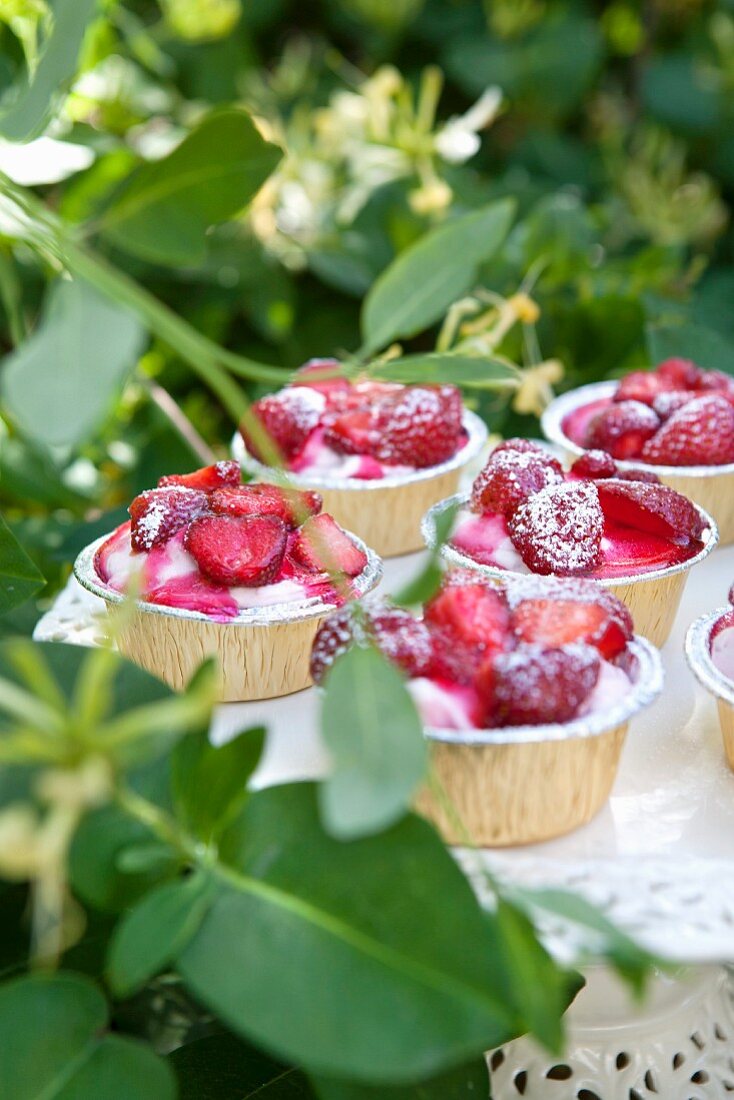 Shrubbery cakes with cream and icing sugar on a garden table