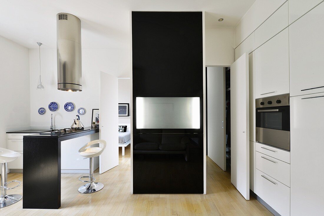 Schwarzer Raumteiler mit eingeklappter Tischplatte in minimalistischer Designerküche