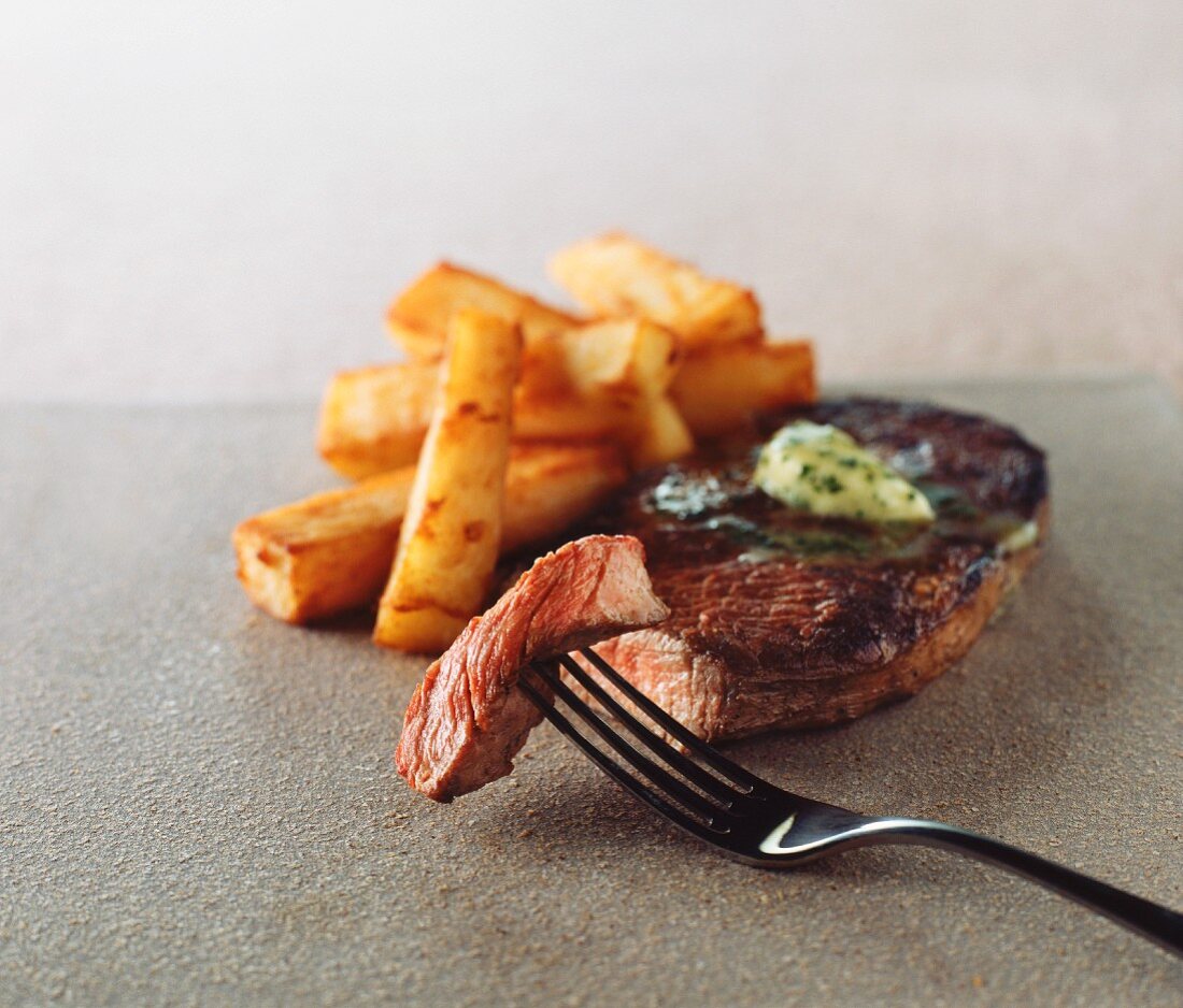 Medium rare steak with chips and garlic butter