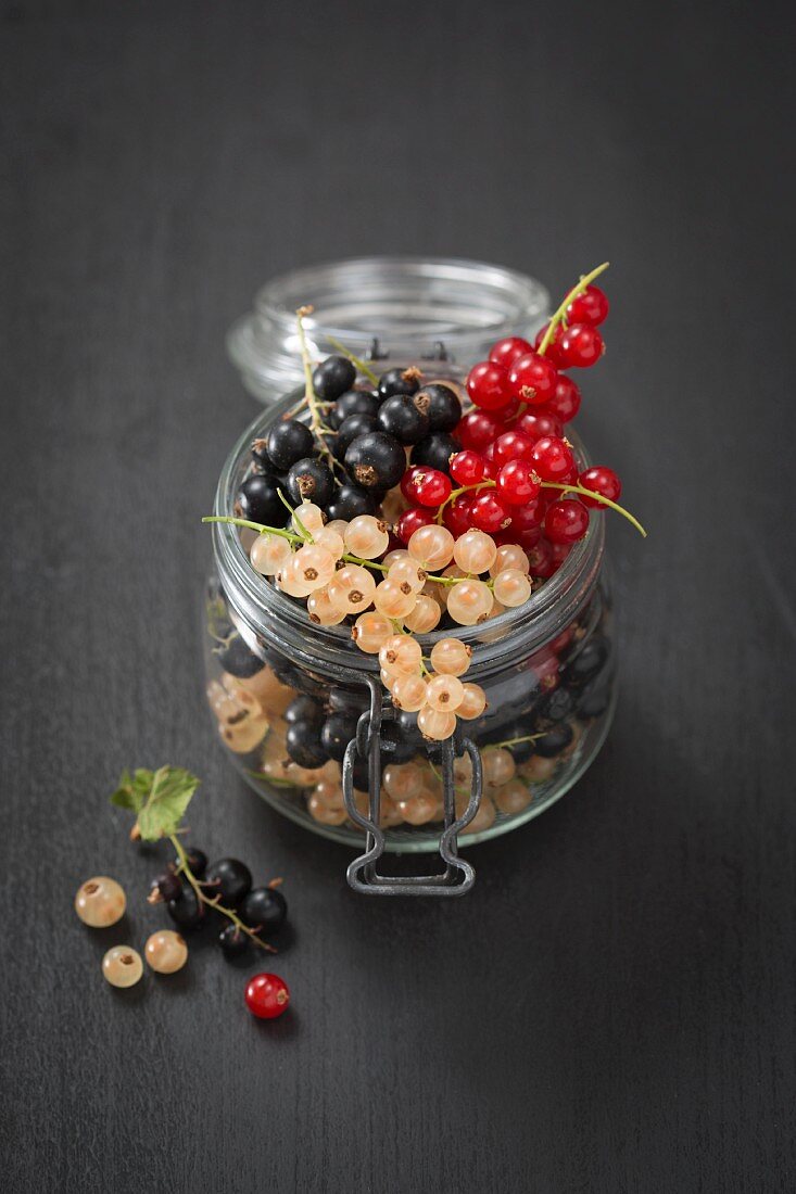 Redcurrants, blackcurrants and white currants in a jar