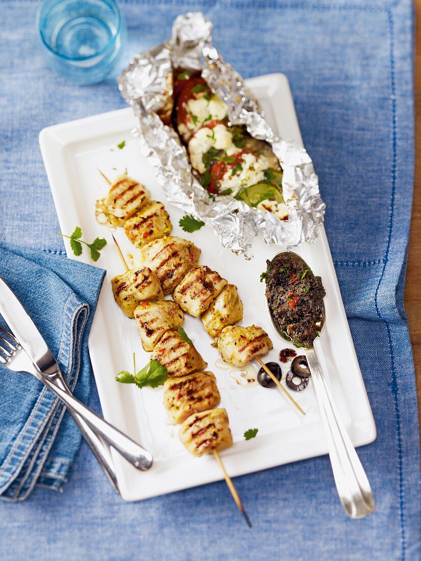 Grilled chicken skewers with olive pesto and foil-baked vegetables