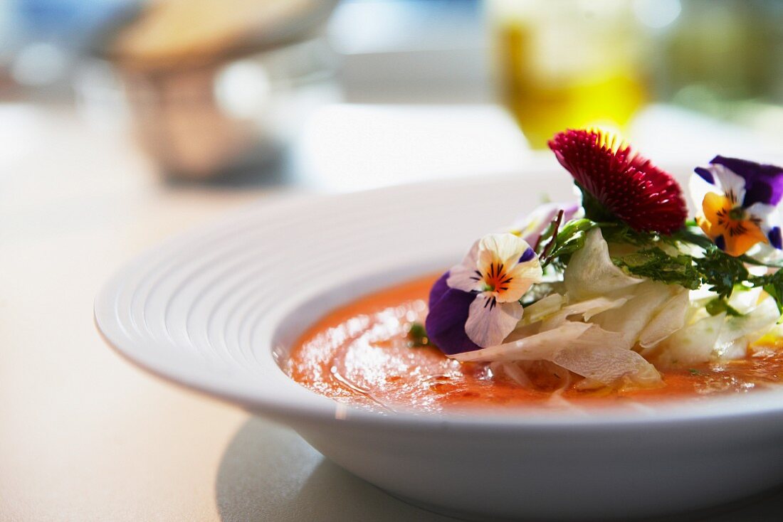 Vegetable soup with edible flowers