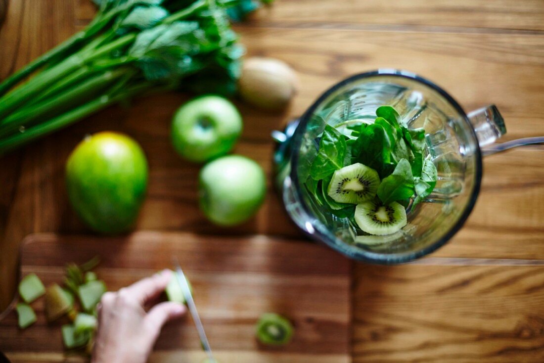 A green smoothie being made in a blender (seen from above)