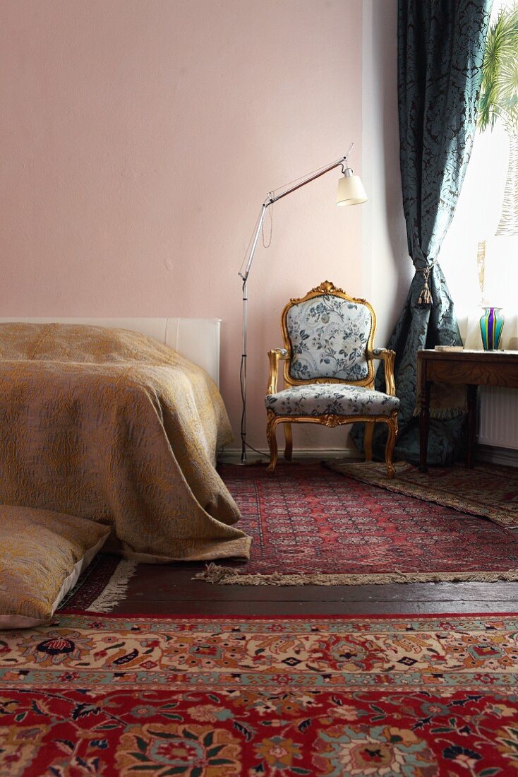 Baroque armchair and various rugs in bedroom