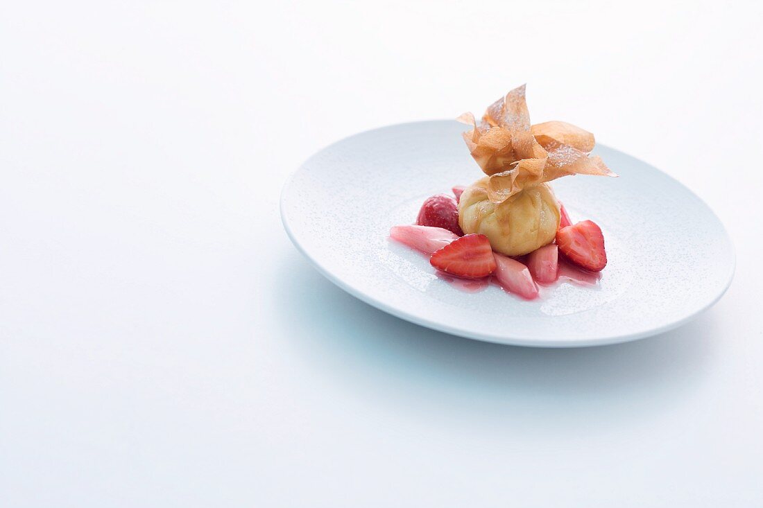 A mini strudel parcel with almond quark on rhubarb and strawberries