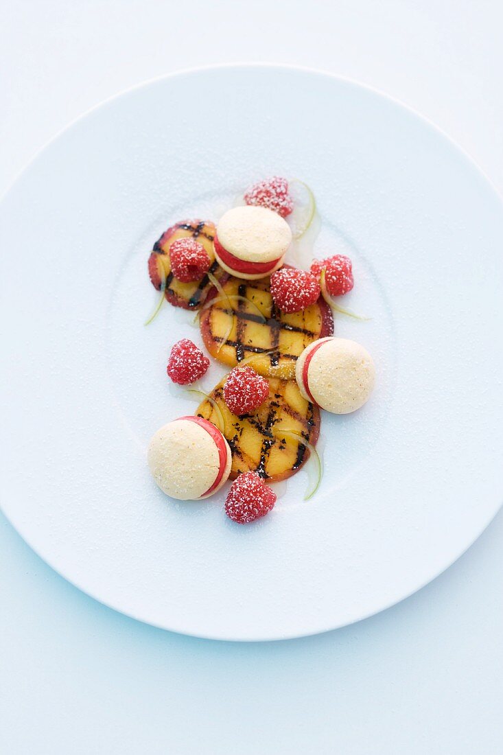 Grilled peach with ice cream macaroons and raspberries