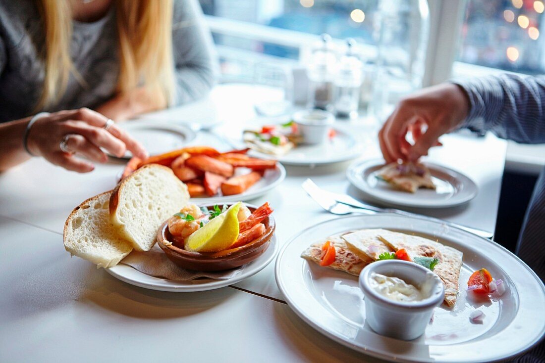 A couple eating brunch and finger food and restaurant