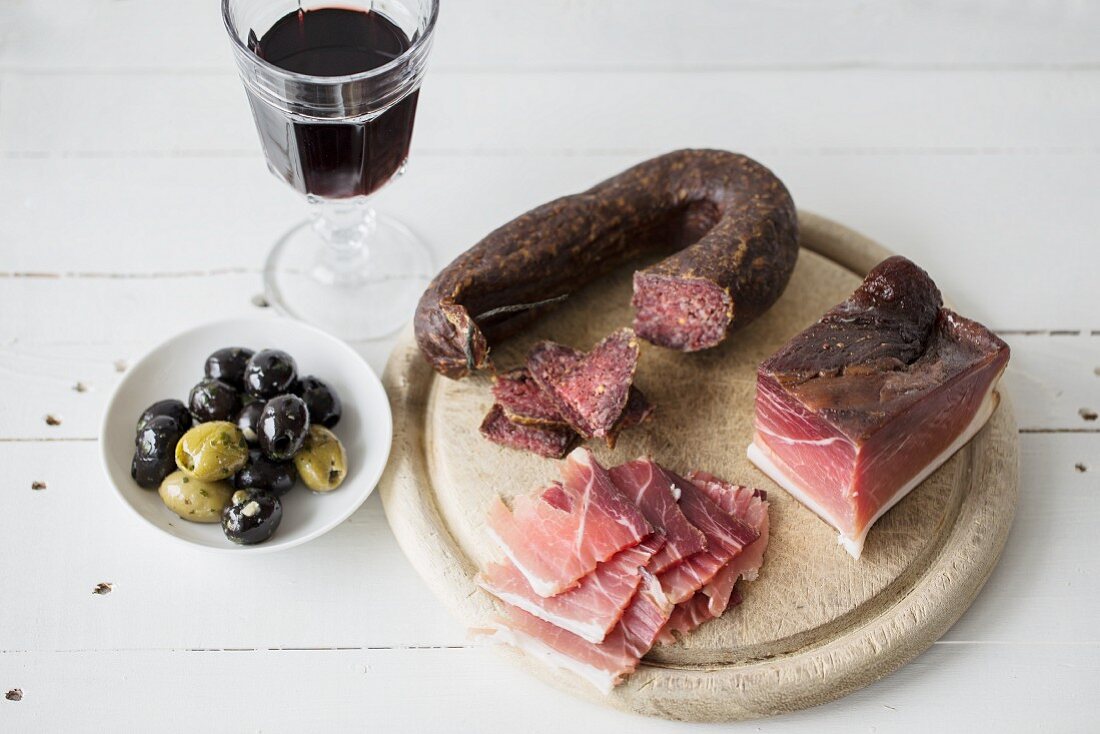 Ham and salami with olives and red wine