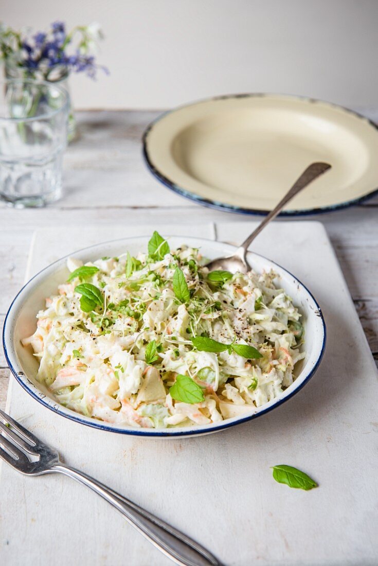 A bowl of coleslaw made with celery, apples and mint