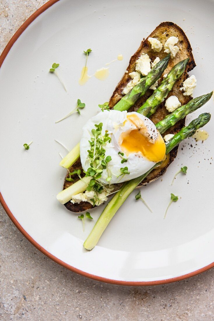 Poached egg on toast with fresh asparagus and ricotta (seen from above)