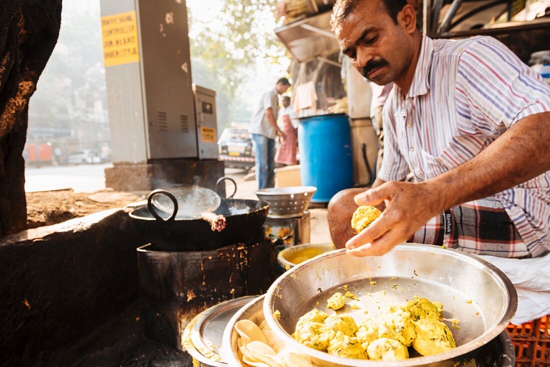 A man eating in a street kitchen (Mumbai, India)