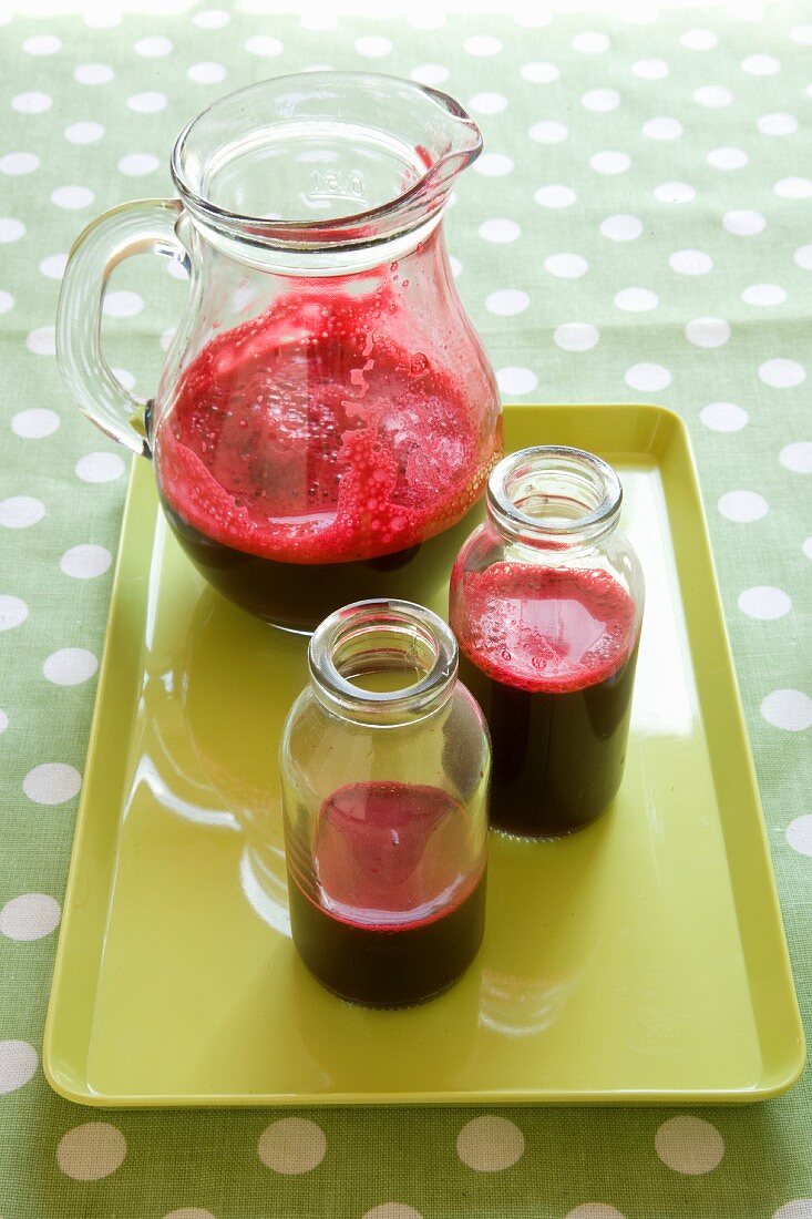 Beetroot juice in bottles and a glass jar