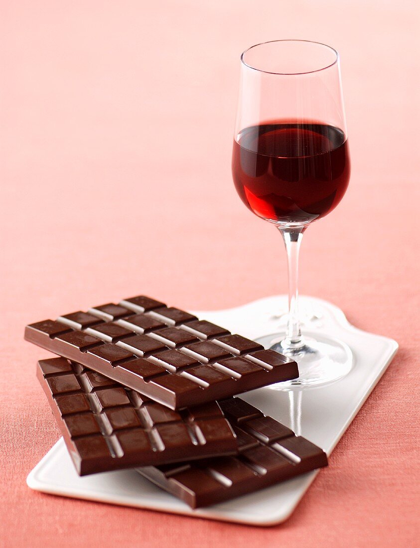 A glass of Barolo and a stacked of chocolate