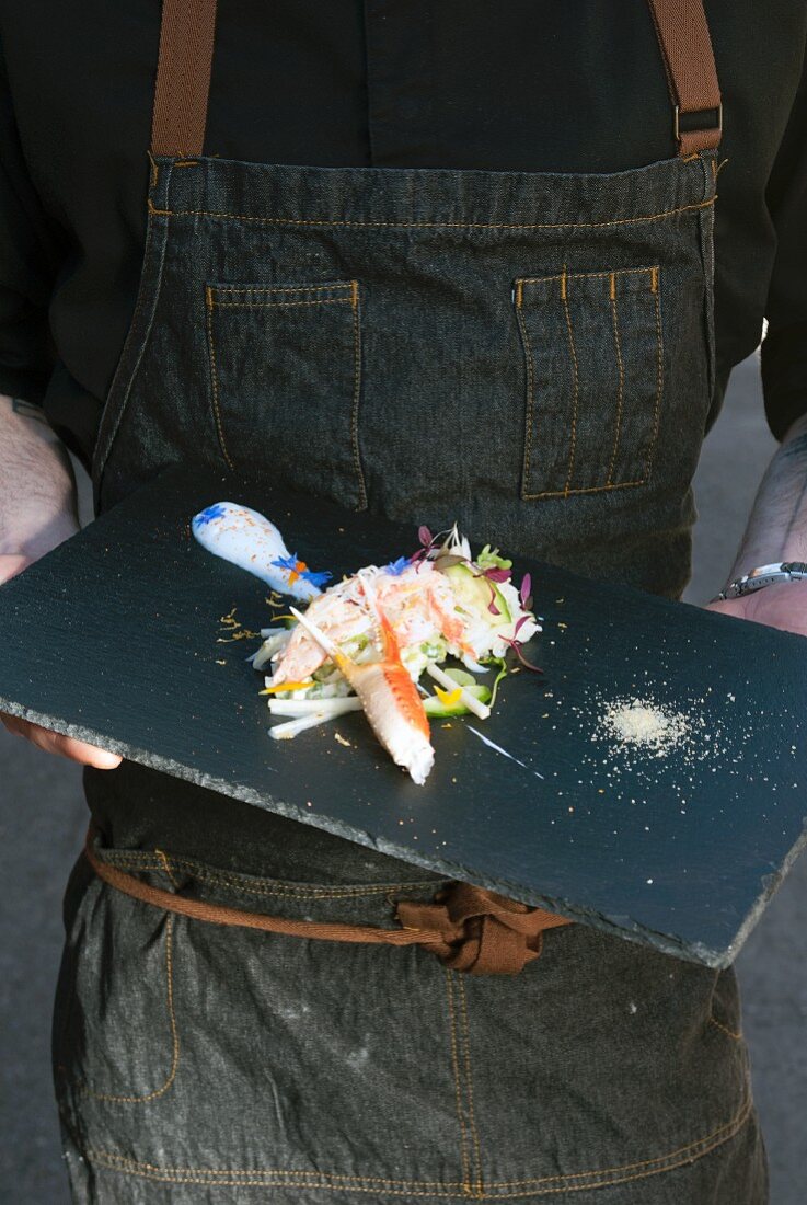 Person hält Servierplatte mit Krabbensalat (Quebec, Kanada)