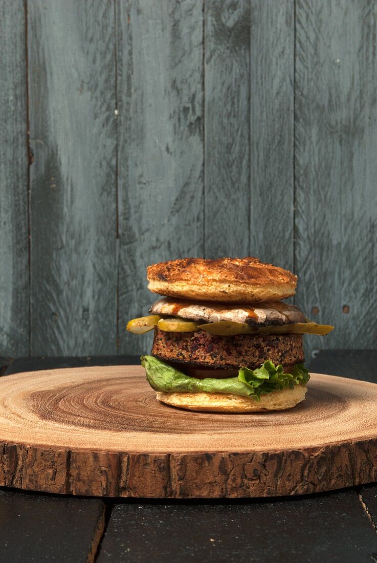 A vegetarian quinoa burger on a slice of wood