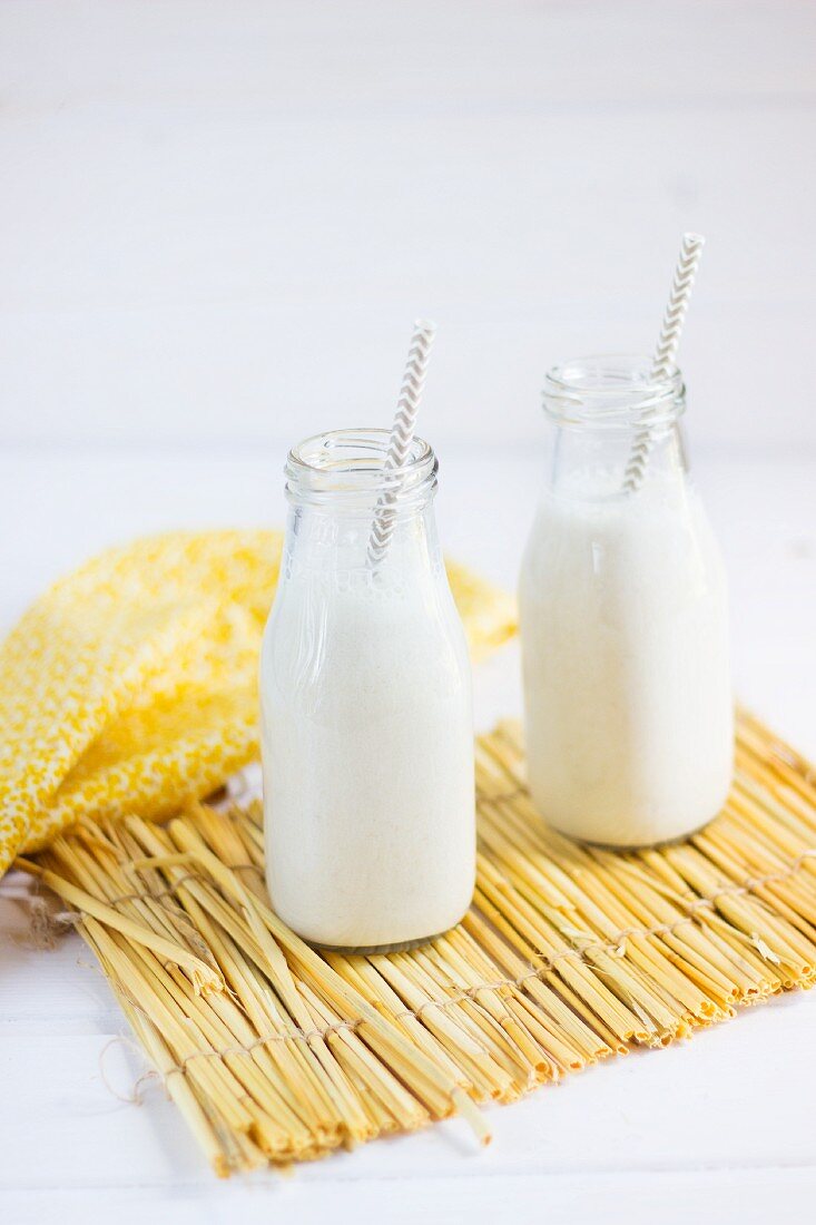 Banana smoothies in glass bottles with straws