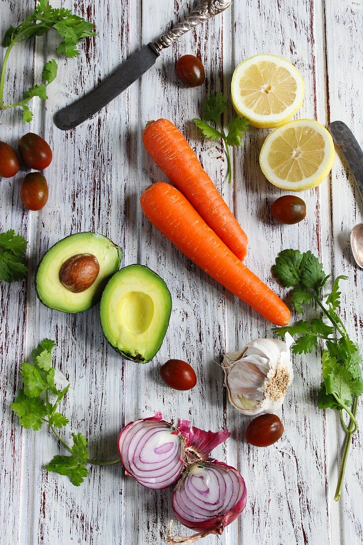 An arrangement featuring avocado, carrots, lemons, onions and tomatoes