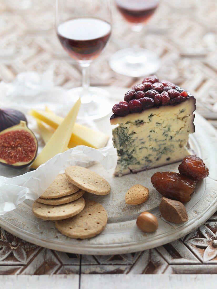 A cheese platter with crackers, nuts, dates and figs