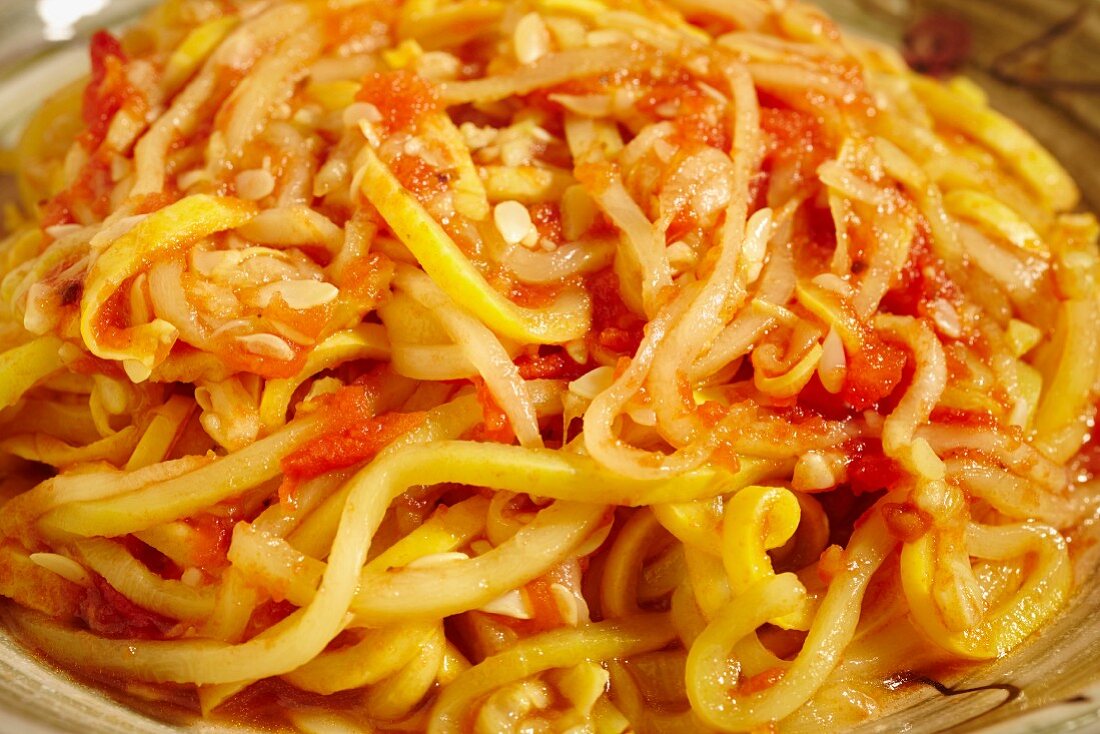 Cooked yellow squash pasta served with tomato sauce