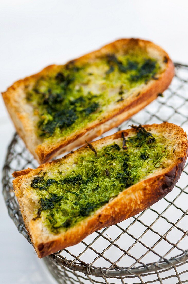 Grilled baguette slices with wild garlic pesto (close-up)